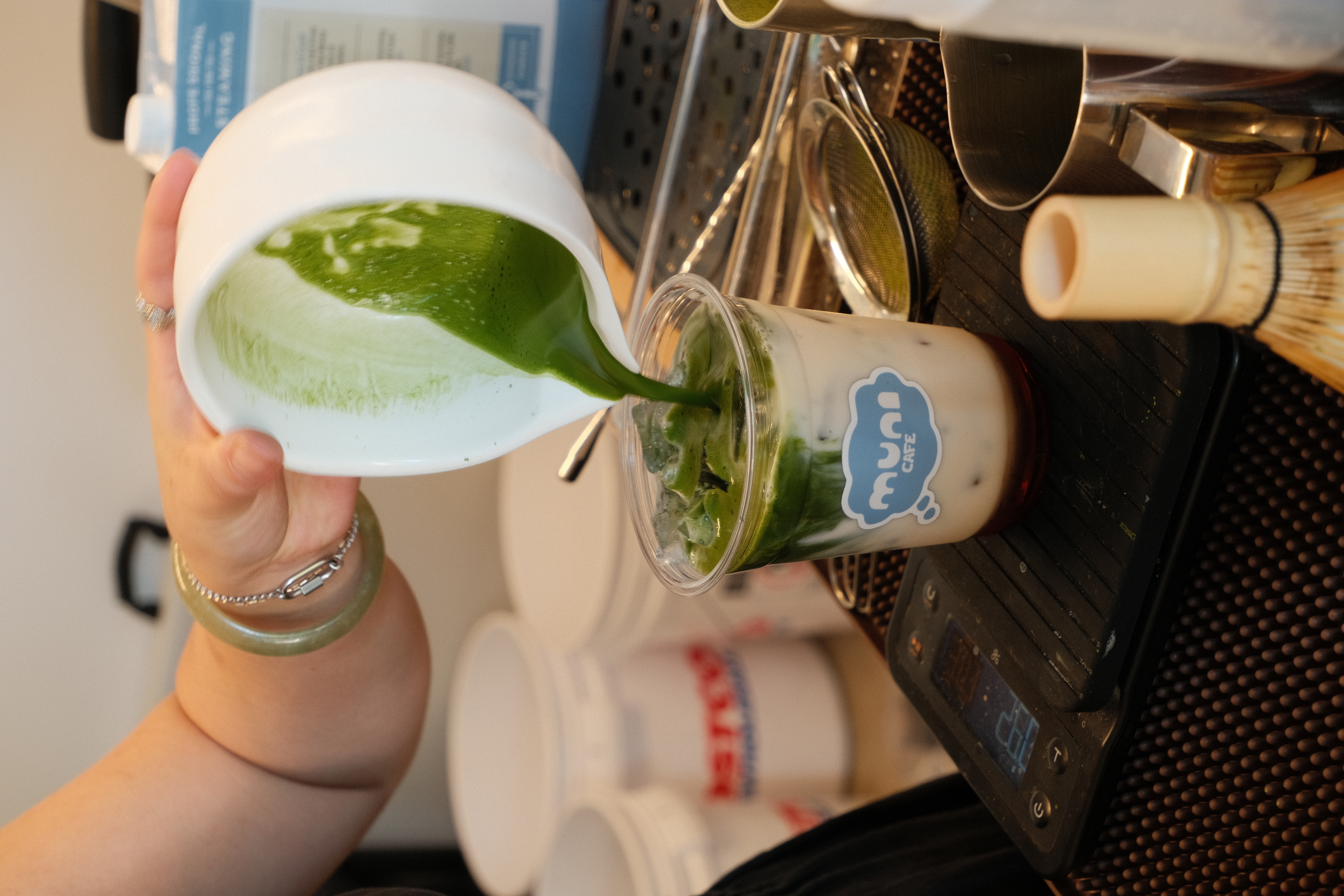 Barista pouring matcha latte at Muni Cafe cart